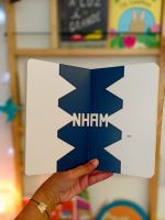 "Nham" é um livro cartonado, de cantos arredondados, convidativo à exploração, que conta a história de três personagens e da sua aventura.